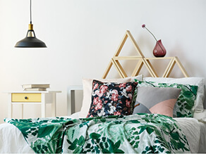 Fresh White Bedroom with green throw blanket and bedside table with yellow drawer and pillows